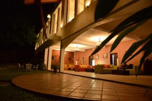 a building with a patio at night with couches at Agbo Hotel in Polonnaruwa