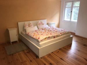 um quarto com uma cama branca com flores em Sanierte möblierte Altbauwohnung am Waldrand für bis zu 6 Personen em Borkheide