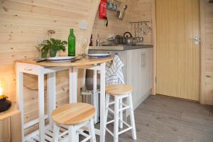 a kitchen with a counter and stools in a tiny house at Clova pod, Kilry eco pods in Blairgowrie