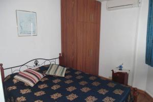 1 dormitorio con 1 cama y armario de madera en Villa Raybaud Résidence Les Cygnes, en Pereybere
