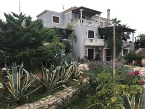 a white house with a garden in front of it at Loy Loy House in Koilás