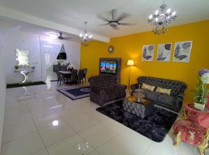 a living room with couches and a dining room at D'Tempat in Kampong Baharu Jimah