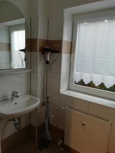 a bathroom with a sink and a mirror and a window at Ferienwohnung Weimar - Ulla in Weimar