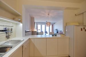 a large kitchen with a sink and a refrigerator at Seascape in Ostend +5 photos
