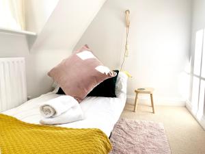 uma cama com almofadas num quarto em Modern Stylish Cambridge Pad (Free Parking) em Histon