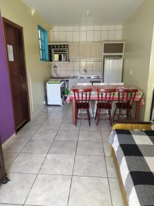 una cocina con mesa y sillas rojas. en Residencial Caxias, en Bombinhas
