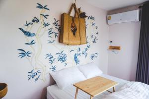 1 dormitorio con flores azules y blancas en la pared en Patoey House en Chon Buri