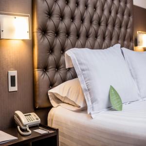 a bed with a white comforter and pillows on it at Del Pilar Miraflores Hotel in Lima