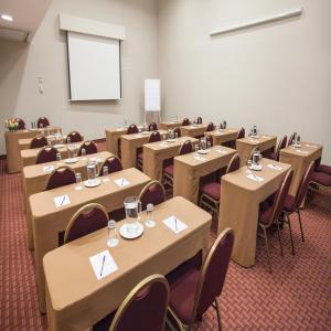 una sala conferenze con tavoli, sedie e schermo di Del Pilar Miraflores Hotel a Lima