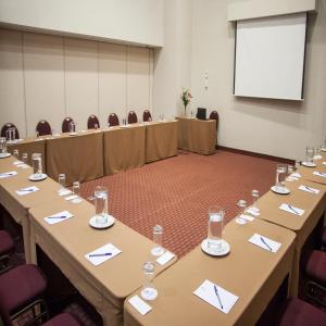a conference room with tables and chairs and a projection screen at Del Pilar Miraflores Hotel in Lima