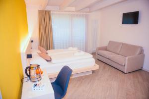 uma pequena sala de estar com uma cama e um sofá em Agritur Verderame em Trento