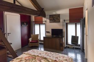 a bedroom with a bed and a desk and a television at B&B MI Casa Tu Casa in Pavia