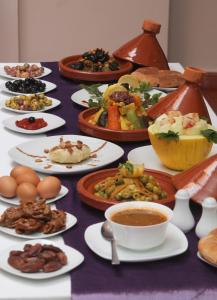 une table avec des assiettes de nourriture et des tasses de café dans l'établissement Riad De La Semaine, à Marrakech