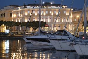 a group of boats in the water in front of a building at Grand Hotel Ortigia in Siracusa