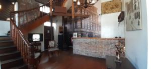 a living room with a staircase and a brick wall at Hotel Reina Victoria Valparaíso in Valparaíso