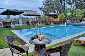 a table and chairs next to a swimming pool at Clarence House Nairobi in Nairobi