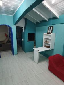 a living room with blue walls and a red couch at Casas 2 Quadras do Mar in Itapema