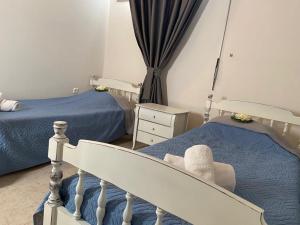 um quarto com 2 camas individuais e uma cadeira em VALENTINA LUXURY em PalaiónTsiflíkion