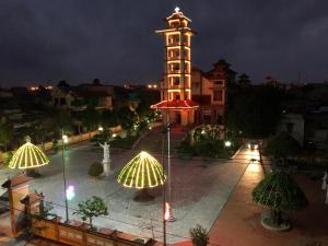 uma torre alta com um relógio à noite em Viet Huong Hotel em Ninh Binh