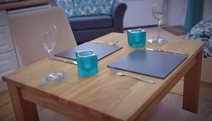 a wooden table with two wine glasses and a table with at A Beautiful Apartment with Stunning Sea Views & Private Balcony in Bournemouth