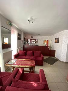 a living room with a red couch and a table at Panama Motel in Székesfehérvár