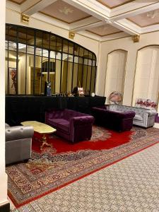 a living room with purple furniture and a red rug at Salon Boyer in Épernay