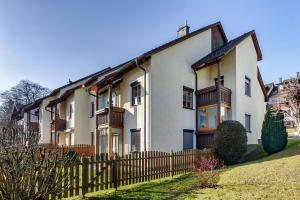 a large white house with a wooden fence at Apartment See und Traunsteinblick in Altmünster