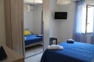 - une chambre avec un miroir et un lit bleu dans l'établissement AFFITTACAMERE AQVA FONTIS, à Campello sul Clitunno