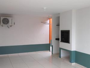 un pasillo con una habitación con TV en la pared en Colônia de Férias de Guaratuba, en Guaratuba