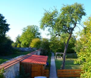 ein Gebäude mit einem roten Dach und einem Baum in der Unterkunft Le Gîte des Sureaux in Rarécourt