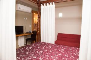 Un dormitorio con una cama y un escritorio con una computadora. en Hotel Boa Vila, en Pontevedra 25 fotos más