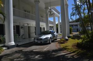 a white car parked in front of a house at Fogo Resort in Escazu
