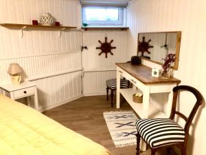 1 dormitorio con escritorio, 1 cama y espejo en Lägenhet i Falkenberg, en Falkenberg