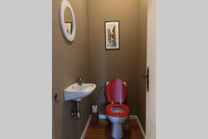 bagno con servizi igienici rossi e lavandino di Appartement dans un bâtiment historique a Thorembais-Saint-Trond