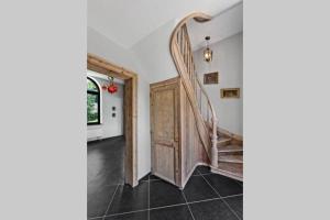 eine Treppe in einem Haus mit einer Holztür in der Unterkunft Appartement dans un bâtiment historique in Thorembais-Saint-Trond