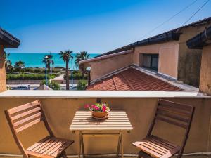 un tavolo con due sedie e un vaso di fiori sul balcone di La Casa di Pippo a Agrigento