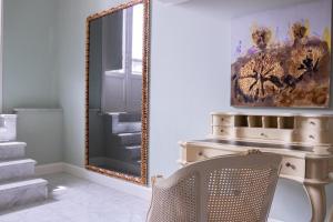 um espelho num quarto com uma cadeira e uma cómoda em Villa Palma Boutique Hotel na Cidade do Panamá