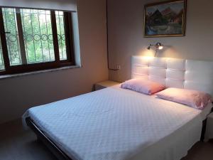 a bedroom with a white bed with a white headboard at Waldvilla in Cıralı