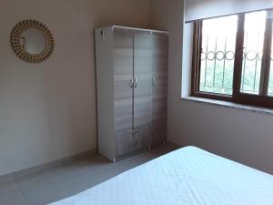 a bedroom with a white cabinet and a window at Waldvilla in Cıralı