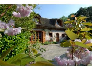 una casa in pietra con tetto di paglia di La Villa Flore a Saint-Jouin-Bruneval