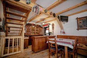 una cocina con armarios de madera, mesa y sillas en Hanul Morii - Pool, Sauna and Jacuzzi en Ciucea