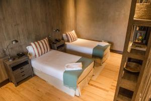 Cette petite chambre comprend deux lits et une chaise. dans l'établissement Estancia La Paz Hotel, à Ascochinga