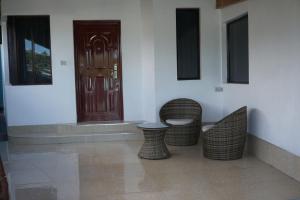 a room with three wicker chairs and a door at Holiday Hire Fiji in Lautoka