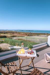 una mesa con un plato de comida en un balcón con vistas al océano en Marlin House II, en Ferrel
