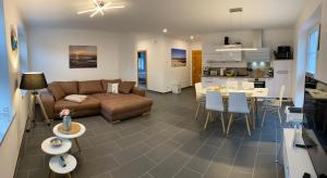 ein Wohnzimmer und eine Küche mit einem Sofa und einem Tisch in der Unterkunft Fewo Barth in Barth