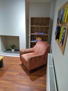 ein Wohnzimmer mit einem Stuhl und einem Bücherregal in der Unterkunft 8A Kenilworth Road in Portsmouth