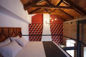 a bedroom with a bed and a brick wall at Carlota Sustainable Design Hotel in Quito