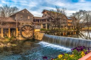 a mill and water wheel in front of a house at Nature's Paradise in Pigeon Forge
