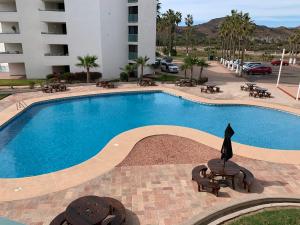 une grande piscine avec des chaises et un bâtiment dans l'établissement Condominios San Carlos, à San Carlos