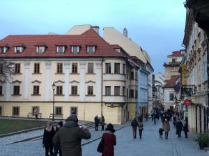 a group of people walking down a street with buildings at Pleasant apartment under the Bratislava castle in Bratislava